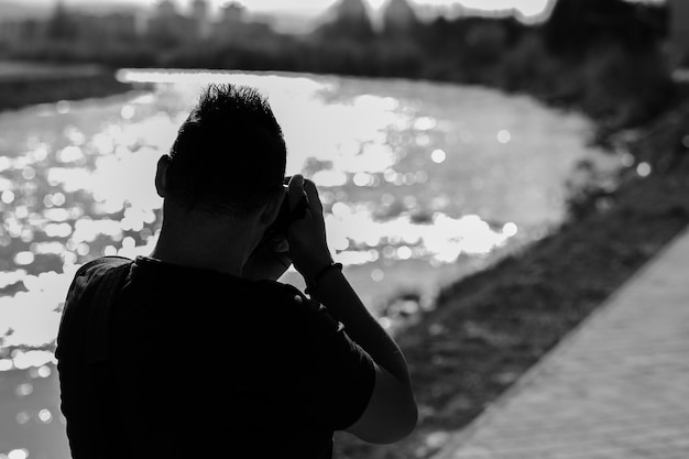 Foto hintergrundansicht eines mannes, der den fluss fotografiert