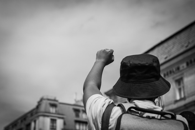 Foto hintergrundansicht eines mannes, der einen hut gegen ein gebäude trägt