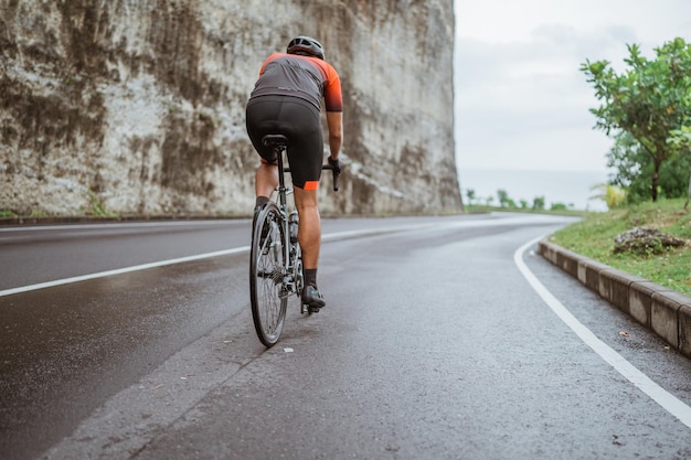 Hintergrundansicht eines Mannes, der Fahrrad auf der Straße fährt