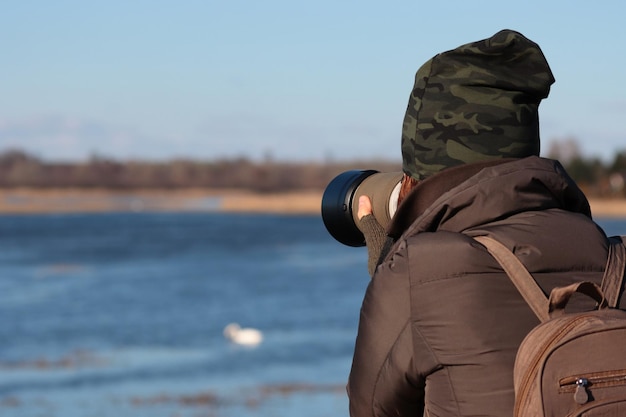 Hintergrundansicht eines Mannes, der gegen einen Meeresfotografen steht