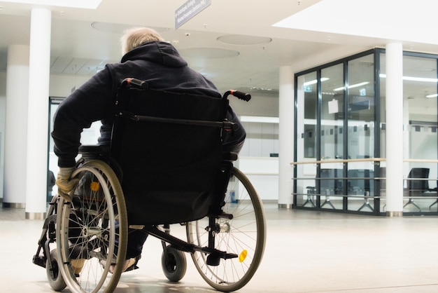 Hintergrundansicht eines Mannes, der im Krankenhaus im Rollstuhl sitzt