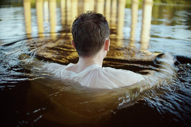 Hintergrundansicht eines Mannes, der im See schwimmt