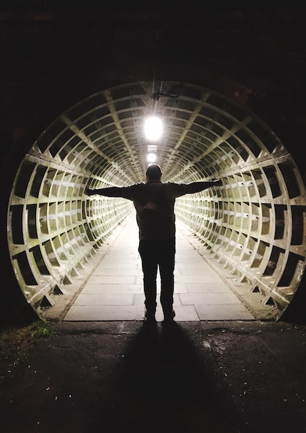 Foto hintergrundansicht eines mannes, der nachts am eingang des tunnels steht