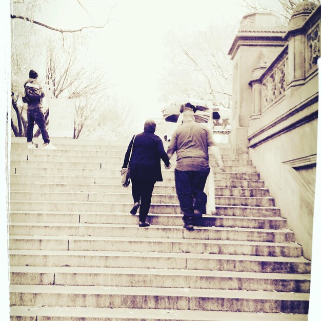 Foto hintergrundansicht eines mannes und einer frau, die auf die treppe steigen