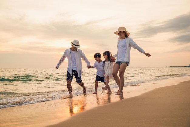 Hintergrundansicht eines Paares, das während des Sonnenuntergangs am Strand gegen den Himmel steht