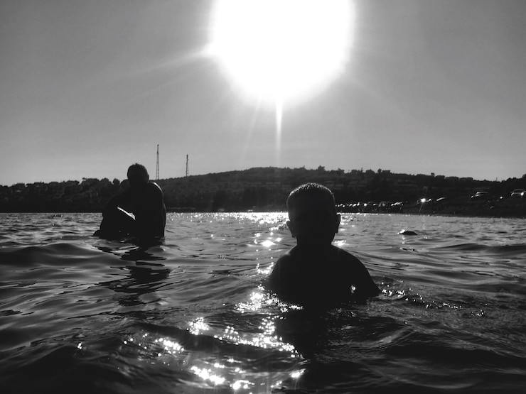Foto hintergrundansicht eines silhouettenjungen im wasser gegen den himmel