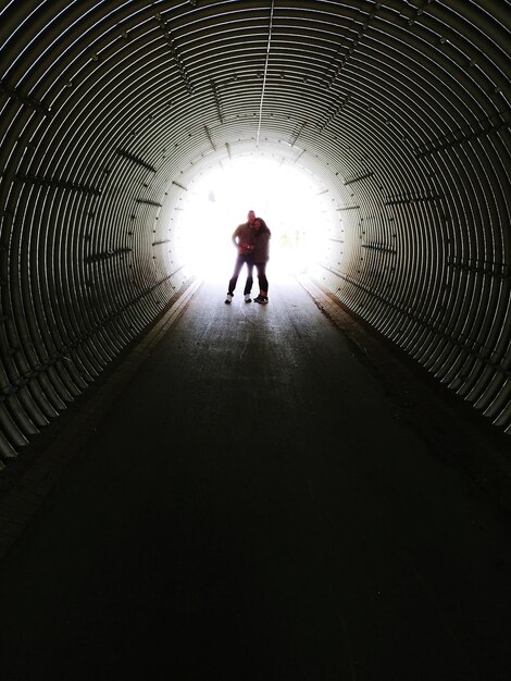 Foto hintergrundansicht eines silhouettenmannes, der im tunnel läuft