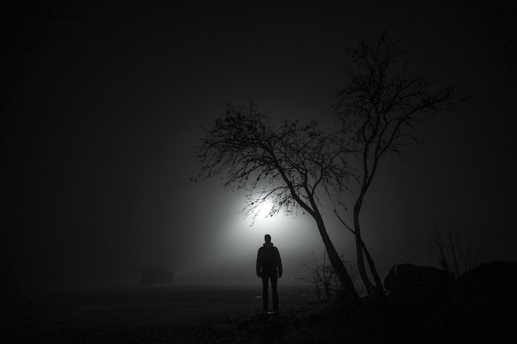 Foto hintergrundansicht eines silhouettenmannes, der nachts auf dem feld steht