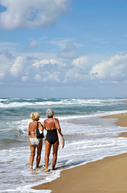 Hintergrundansicht von Freunden am Strand gegen den Himmel