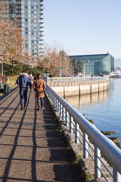 Hintergrundansicht von Menschen auf einem Gehweg am Fluss