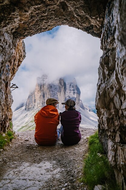 Foto hintergrundansicht von menschen, die im winter auf einem felsen gegen den himmel sitzen