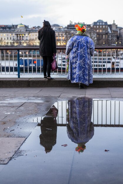 Foto hintergrundansicht von menschen, die in der stadt an einer pfütze stehen