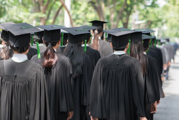 Hintergrundansicht von Studenten, die Abschlusskleider tragen, während sie im Freien stehen