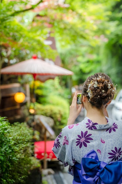 Hintergrundansicht von zwei Frauen, die japanische Yukata-Sommerkimono tragen und in der Natur auf der Straße spazieren gehen