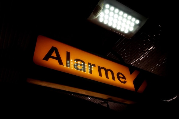 Hintergrundbeleuchtetes gelbes Alarmschild in französischer Sprache