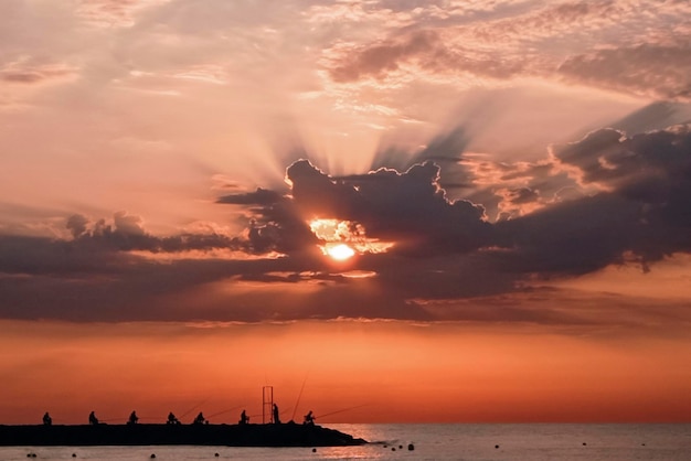 Hintergrundbeleuchtung einer Anlegestelle mit Fischern im Morgengrauen Puerto de Sagunto Valencia, Spanien