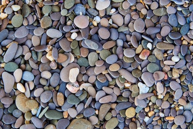 Hintergrundbeschaffenheit von mehrfarbigen Steinen auf dem Strand.