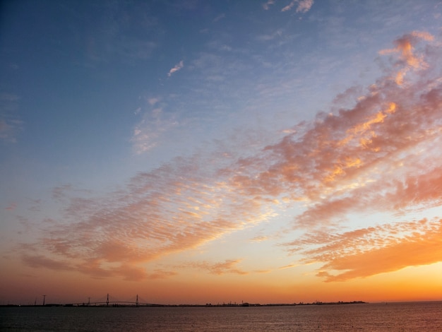 Hintergrundtextur des schönen orange und blauen Sonnenunterganghimmels mit Wolken