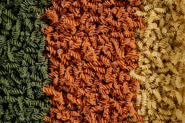 Hintergrundtextur von dreifarbigen Fusilli-Nudeln für traditionelle italienische und mediterrane Küche in einer Nahaufnahme im Vollformat. Foto in hoher Qualität