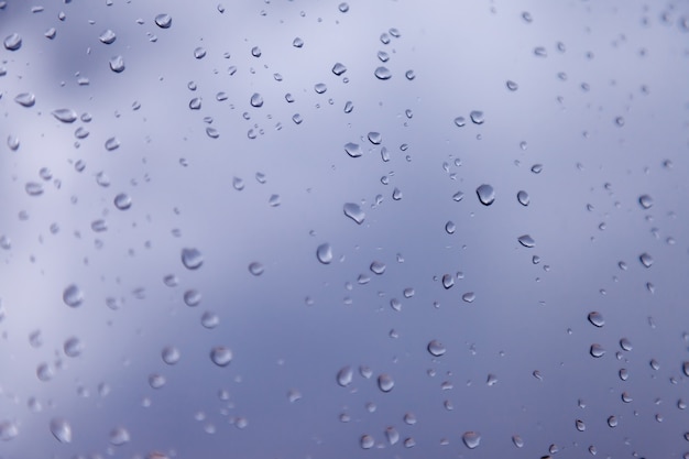 Hintergrundwassertropfen. Regentropfen auf Fensterscheiben. Natürliches Muster von Regentropfen. Abstrakter Schuss von Regentropfen auf Glas. Abstrakter fallender Regentropfen des Regens auf Glas. Platz für eine Inschrift oder ein Logo