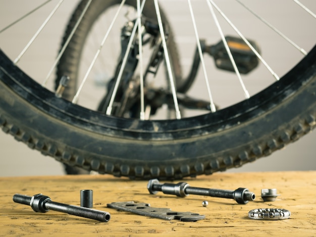 Foto hinterradmountainbike und -werkzeuge auf einem holztisch.