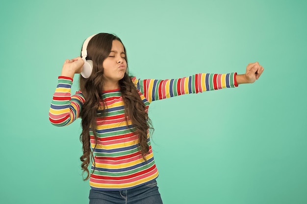 Hip hop niña pequeña niña escuchar música en auriculares feliz bailando niño adolescente niño expresar positividad colegiala optimista usar ropa colorida mejores éxitos de verano en tono positivo atrapar mi ola