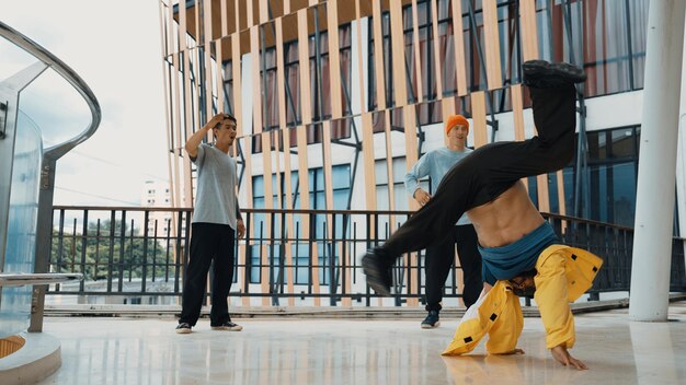 Foto hip-hop-team tanzt breakdance, während multikulturelle freunde endeavor umgeben