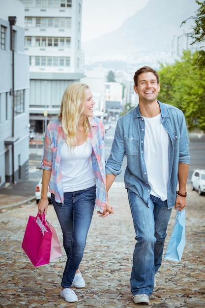 Hip jovem casal em viagem de compras andando subindo