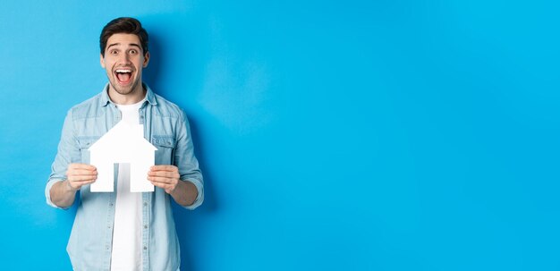 Foto hipoteca de seguro e conceito imobiliário homem feliz segurando modelo de casa e comprando animado sorrindo