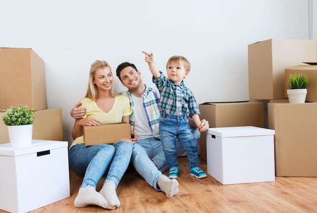 hipoteca, pessoas, habitação e conceito imobiliário - família feliz com caixas se mudando para uma nova casa