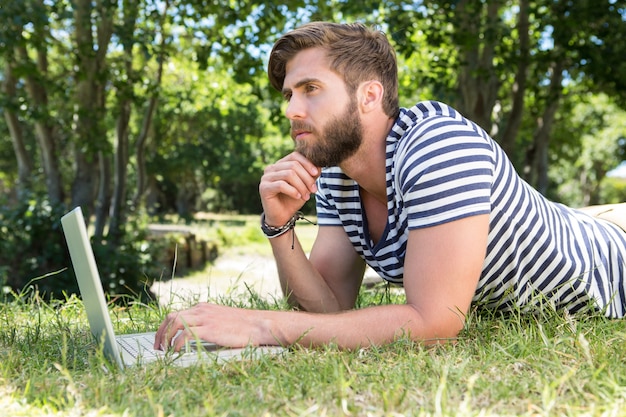 Hippie, der Laptop im Park verwendet