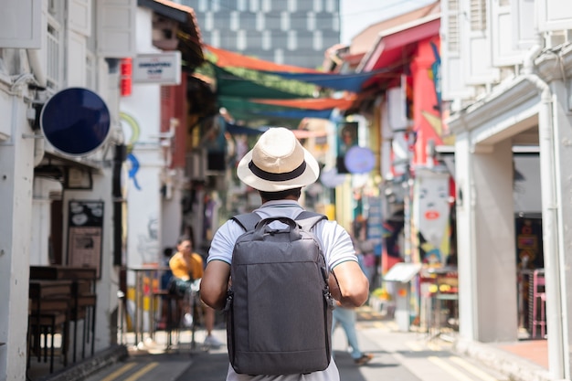 Hippie des jungen Mannes, der mit Rucksack und Hut reist