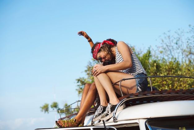 Hippie-Leute, die auf dem Dach von Van Road Trip Travel sitzen