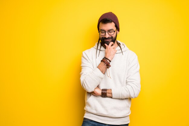 Hippiemann mit den Dreadlocks, die unten mit der Hand auf dem Kinn schauen