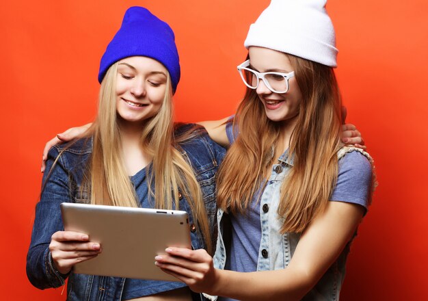 Hipster amigas tomando selfie con tableta digital, estudio