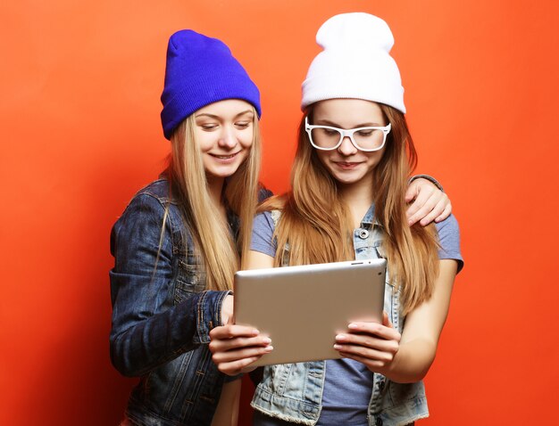 Hipster amigas tomando selfie con tableta digital, estudio