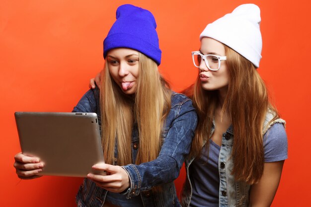 Hipster amigas tomando selfie con tableta digital