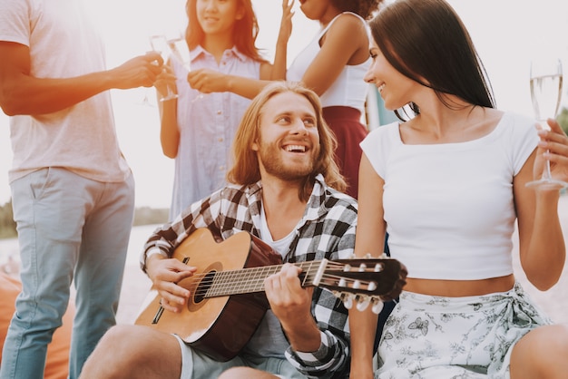 Hipster amigos tocando guitarra y cantando.