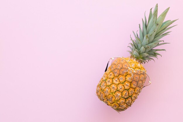 Hipster-Ananas mit trendiger Sonnenbrille vor rosa Hintergrund Minimales Sommerkonzept