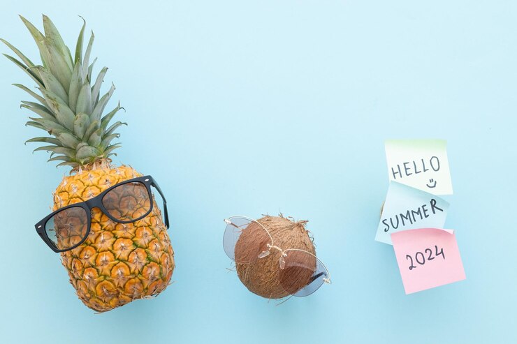 Foto hipster-ananas und kokosnuss mit sonnenbrille vor blauem hintergrund