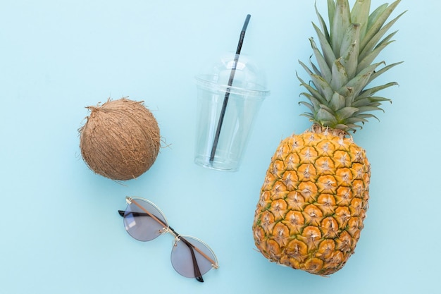 Hipster-Ananas und Kokosnuss mit Sonnenbrille vor blauem Hintergrund