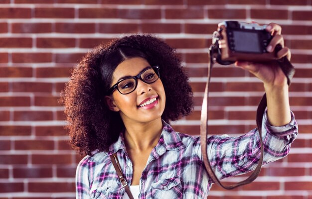 Hipster atraente que toma selfies com câmera