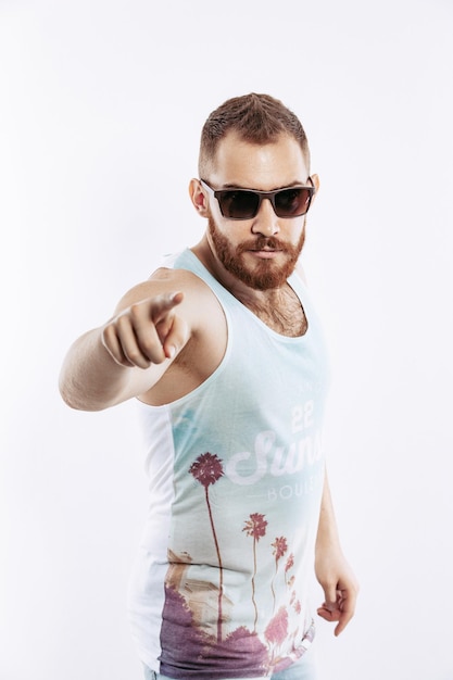 Hipster bärtiger Rotschopf, der mit dem Zeigefinger vor sich auf die Kamera auf weißem Hintergrund zeigt