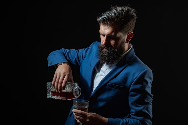 Hipster con barba y bigote en traje bebe alcohol después de la jornada laboral Sommelier prueba una bebida alcohólica cara