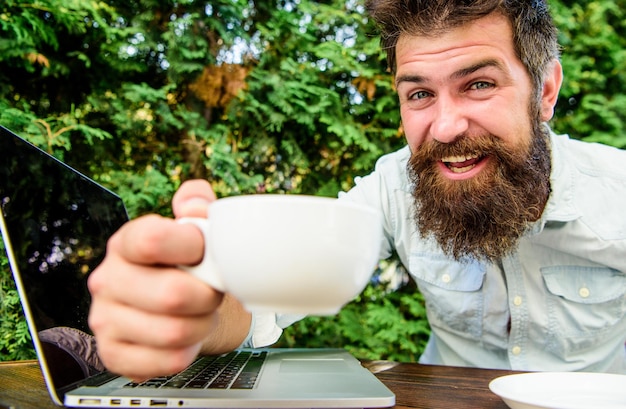 Hipster barbudo brutal en el descanso para tomar café hombre feliz trabajando en una computadora portátil trato perfecto oficinista Exitoso hombre de negocios negocio ágil Éxito empresarial Lo logramos