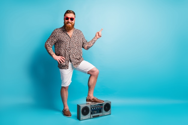 Hipster barbudo homem ouvir toca-fitas jogador direto dedo direto espaço vazio