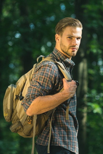 Hipster barbudo senderismo vacaciones salvaje aventura joven senderismo en el bosque y respira aire puro en