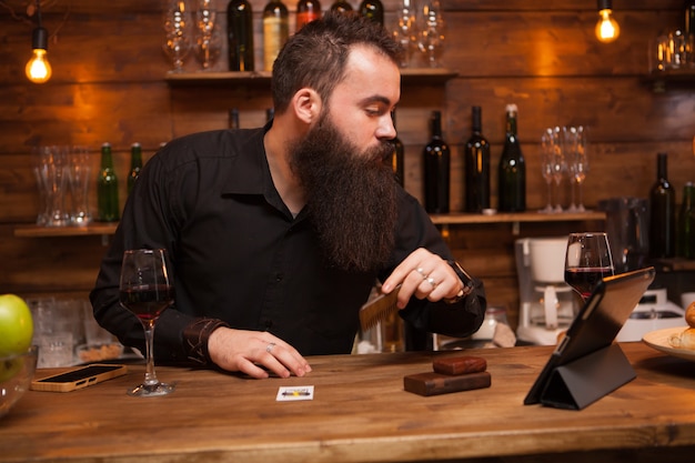 Hipster-Barkeeper, der sich um seinen langen Bart kümmert. Toller Bart.