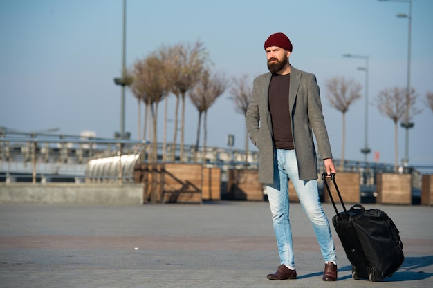 Hipster bereit, Reise zu genießen Reisetasche tragen Geschäftsreise Mann bärtige Hipster-Reise mit großer Gepäcktasche auf Rädern Lassen Sie die Reise beginnen Reisende mit Koffer kommen zum Bahnhof des Flughafens