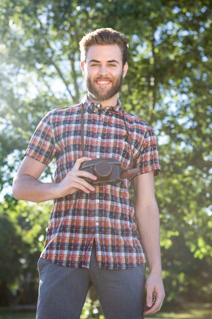 Hipster bonito usando câmera vintage